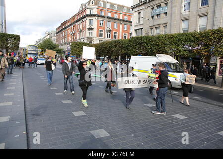Dublino, Irlanda. Il 15 ottobre 2013. I manifestanti marzo verso il basso O'Connell Street. Numerose proteste sono state andando su nel centro di Dublino il giorno il ministro delle Finanze Michael Noonan si appresta a presentare il bilancio per il 2014. Essi protesta contro l'aumento delle tasse e i tagli nella spesa pubblica. Foto Stock