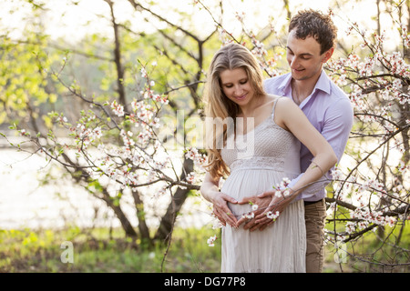 Giovane coppia incinta all'aperto in primavera Foto Stock