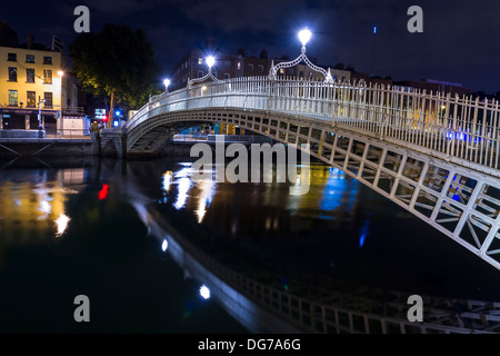 Dublino, Irlanda - 14 Ottobre 2013: l'Ha'penny Bridge in una notte buia sul Fiume Liffey nel centro di Dublino. Foto Stock