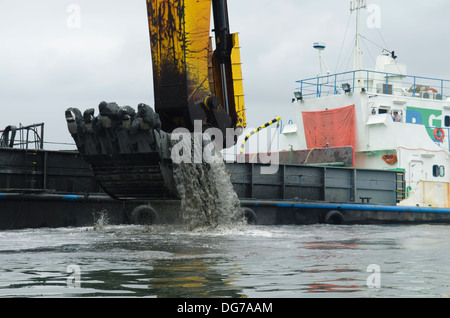 Rimorchiatore nave scavando a Santos (Sao Paulo, Brasile) porto canale per renderla più profonda per i pescherecci più grandi pass Foto Stock