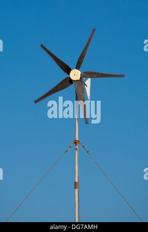 Elica in movimento da una piccola turbina eolica nel cielo azzurro di Folegandros, Grecia, 2013. Foto Stock