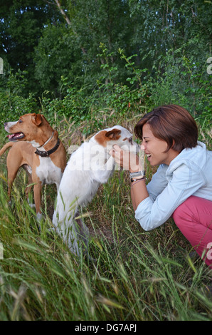 Giovane donna a giocare con i suoi cani Foto Stock