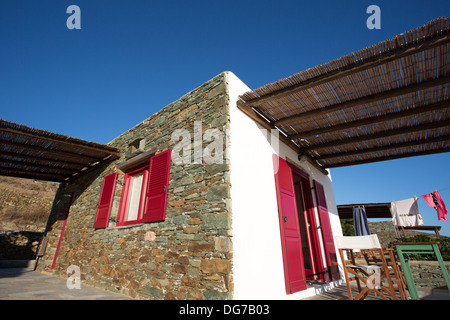 Tipico greco terrazza a Folegandros, e una vista di una camera di albergo e appariscente red porte. Foto Stock