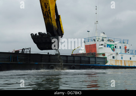 Rimorchiatore nave scavando a Santos (Sao Paulo, Brasile) porto canale per renderla più profonda per i pescherecci più grandi pass Foto Stock