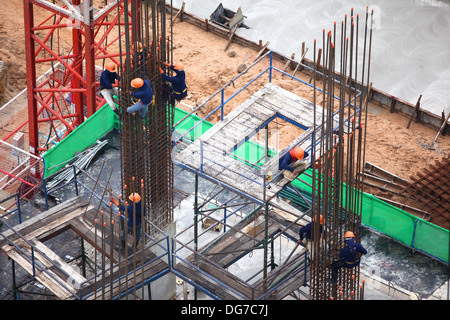 Lavoratori edili e di rinforzo del cemento armato Foto Stock