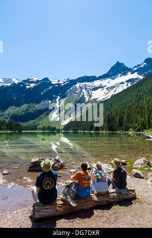 Walkers avente un picnic sulle rive del lago di valanghe, Avalanche Lago Trail, il Parco Nazionale di Glacier, Montana, USA Foto Stock