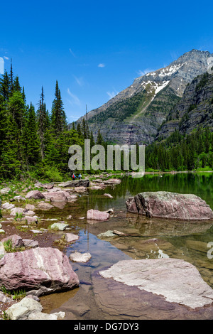 Gli escursionisti sulla riva del lago di valanghe, il Parco Nazionale di Glacier, Montana, USA Foto Stock