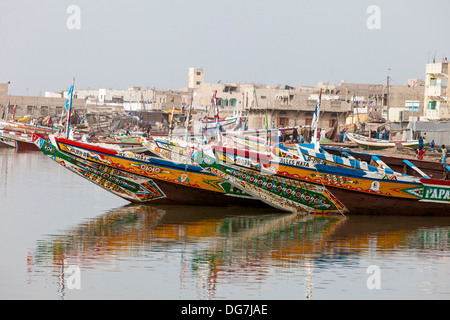 Il Senegal, Saint Louis. Guet N'Dar quartiere, decorate luminosamente barche da pesca legato lungo il fiume Senegal. Foto Stock