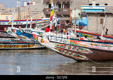 Il Senegal, Saint Louis. Guet N'Dar quartiere, decorate luminosamente barche da pesca legato lungo il fiume Senegal. Foto Stock