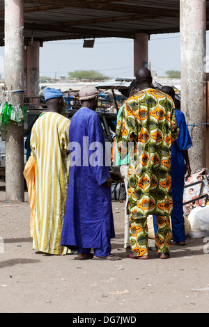 Il Senegal, Saint Louis. Gli uomini in un colorato Boubous africana, alla fermata degli autobus e dei taxi. Foto Stock