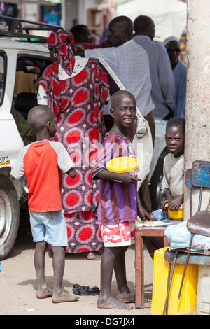 Il Senegal, Saint Louis. Tre ragazzi alla fermata degli autobus e dei taxi. Foto Stock