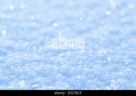 Blu neve scintillante sfondo bianco con piccoli fiocchi di neve. Foto Stock