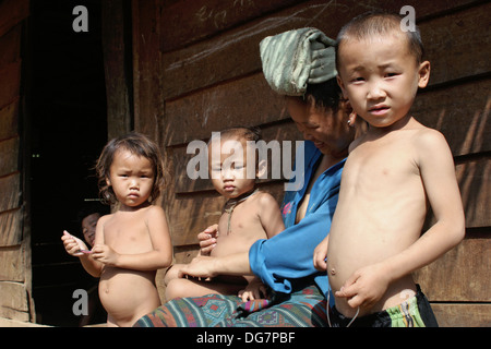 Un etnia Hmong hilltribe la famiglia è riunita davanti alla loro casa in Luang Prabang Provincia, Laos. Foto Stock