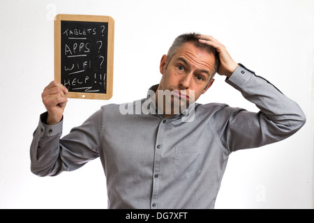 Confuso uomo in possesso di una compressa di Blackboard Foto Stock