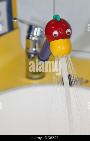 Toccare in un punto rosso e giallo novità fun duck il design della testa è acceso la spruzzatura di acqua in una vasca di lavaggio in un parco giochi per bambini bagno Foto Stock