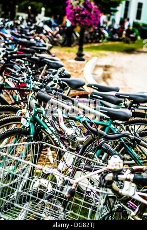 Le biciclette in una fila sulla isola di Mackinac in attesa per i noleggiatori. Foto Stock