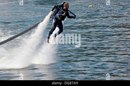 Uomo di pilotaggio alimentata acqua jet pack ad alta velocità Royal Victoria Dock LONDRA Inghilterra Europa Foto Stock