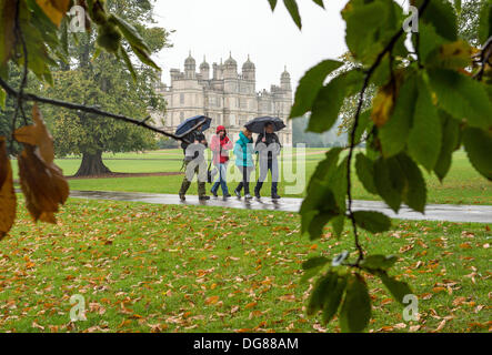 Burghley park, Stamford, Lincolnshire, Regno Unito. Il 16 ottobre 2013. I visitatori di Burghley park, vicino a Stamford nel Lincolnshire, a piedi attraverso la pioggia d'autunno. Credito: Lovelylight/Alamy Live News Foto Stock