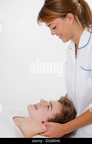 Giovani femmine osteopata medico curante giovane maschio con dolore al collo facendo osteopatia il trattamento Foto Stock