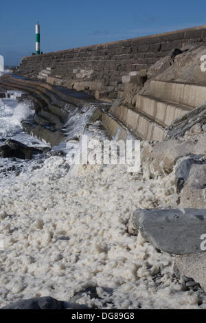 Aberystwyth, Wales, Regno Unito, 16 ottobre 2013. Gale venti della forza di raggiungere il Galles centrale costa durante il primo pomeriggio. La schiuma agitati da venti sale al di sopra della parete del porto, sblowing schiuma verso la città. Credito: atgof.co/Alamy Live News Foto Stock
