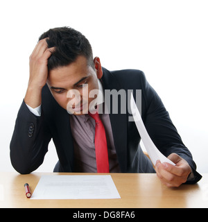 L'uomo leggendo il contratto alla sua scrivania Foto Stock