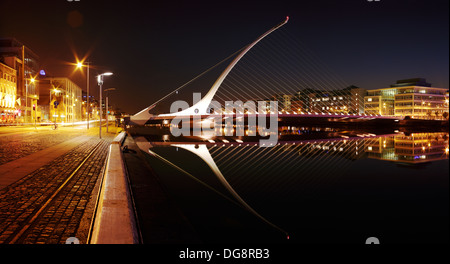 Vista notturna di Samuel Beckett Bridge dall'architetto Santiago Calatrava e di entrambe le sponde del fiume Liffey nel centro della città di Dublino Foto Stock