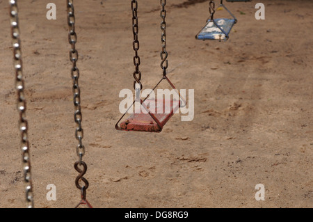 Un vecchio swing sul parco giochi abbandonato Foto Stock