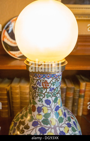 Una vecchia lampada elettrica, il primo al mondo a utilizzare il nuovo inventato lampadina elettrica a Cragside, Rothbury, Northumberland, la casa del Signore Armstrong, Vittoriano di un ingegnere e inventore, che girò Cragside nella prima casa in tutto il mondo per essere illuminato da energia idroelettrica. Foto Stock