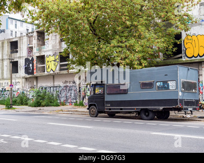 Mobile home parcheggiata fuori abbandonato coperto di graffiti fabbrica del ghiaccio Building a Berlino Foto Stock