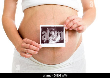 Donna incinta holding di scansione ad ultrasuoni sul suo ventre Foto Stock