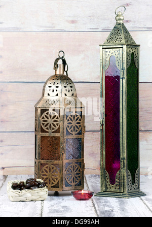 Vetro e bronzo in metallo colorato lanterne con candela e cesto di date Foto Stock