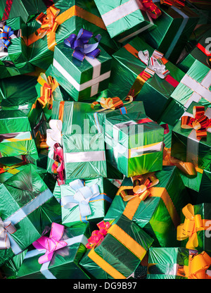 Sfondo fotografico con enorme pila di verde brillante scatole regalo con archi colorati Foto Stock