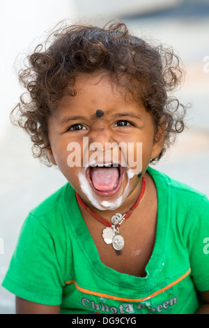 Giovane ragazza indiana / bambino mangiare il gelato in un territorio rurale villaggio indiano. Andhra Pradesh, India Foto Stock