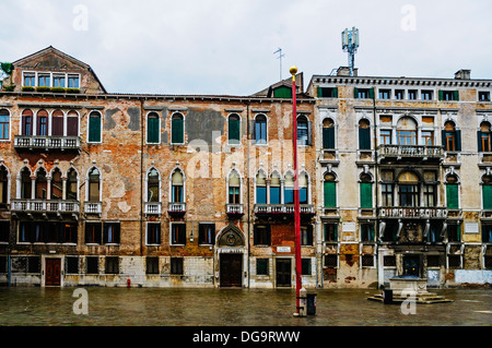 Il degrado delle facciate di edifici imponenti che rispecchiano ancora la grandezza della loro ex stessi in Campo de Maurizio, Venezia Foto Stock