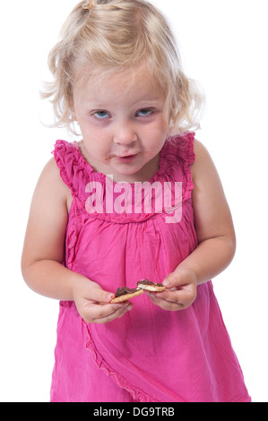 Bambina in rosa di mangiare un biscotto, isolato su sfondo bianco Foto Stock