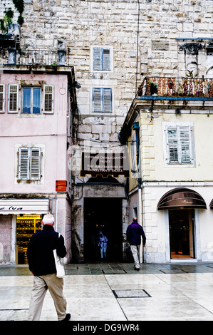 Lone turisti testa verso il sotterraneo mare meridionale porta nelle mura del palazzo costruito dall'imperatore romano Diocleziano Foto Stock