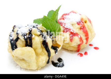 Due eclairs decorate con salsa alla menta e uno sfondo bianco Foto Stock