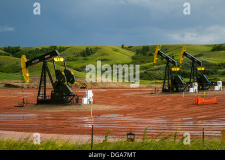 Olio pumpers nel gioco Bakken, olio di scisto campi nelle colline vicino a Williston, il Dakota del Nord, Stati Uniti d'America. Foto Stock