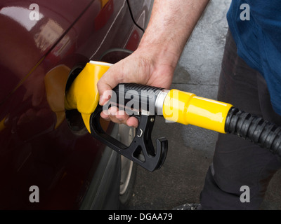 Persona il pompaggio del gas in corrispondenza di una stazione di gas Foto Stock