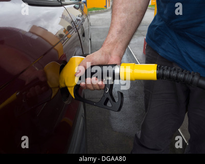 Persona il pompaggio del gas in corrispondenza di una stazione di gas Foto Stock