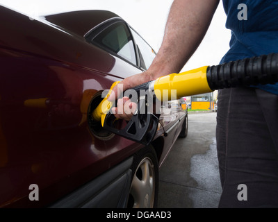 Persona il pompaggio del gas in corrispondenza di una stazione di gas Foto Stock