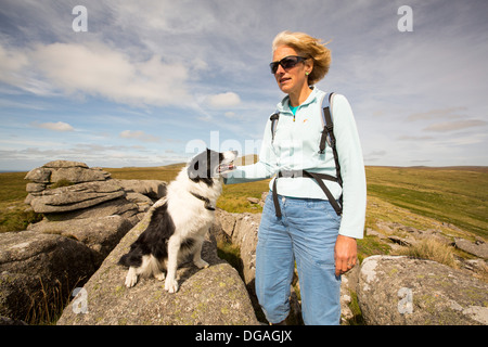 Tori di granito su Ger tor, Dartmoor Devon, Regno Unito, con una donna walker e cane. Foto Stock