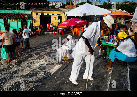 Un devoto candomblé salite le scale nella parte anteriore del San Lazzaro Chiesa in Salvador, Bahia, Brasile. Foto Stock