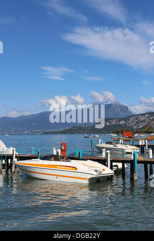 Vista di una barca a motore ad un pontile in legno sul Lago di Garda tra Bardolino e Cisano in Italia Foto Stock