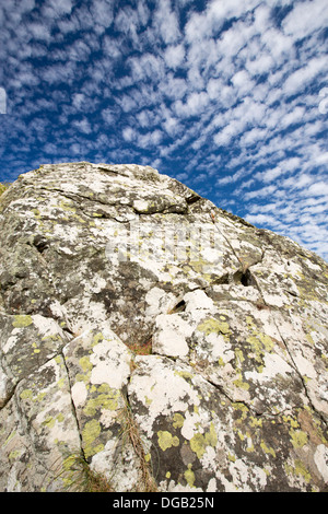 I modelli cloud al di sopra di un lichene coperto sul rock Cornish Coast vicino Zennor, UK. Foto Stock