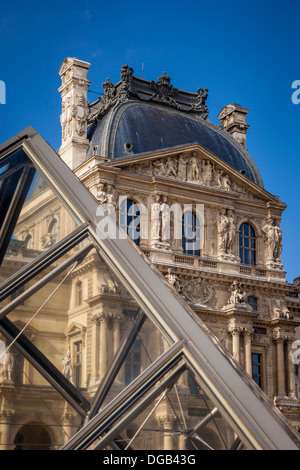 La piramide di vetro al di sotto delle architetture riccamente ornate di Musee du Louvre, Parigi Francia Foto Stock