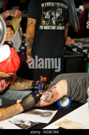 Un tatuaggio artista / inchiostratore tatuaggio di una gamba di persone Foto Stock
