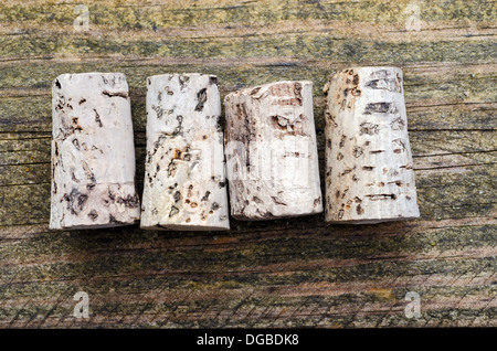Cinque vecchi tappi su una tavola di legno Foto Stock