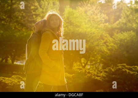 Due giovani donne in piedi di schiena in posizione di parcheggio Foto Stock