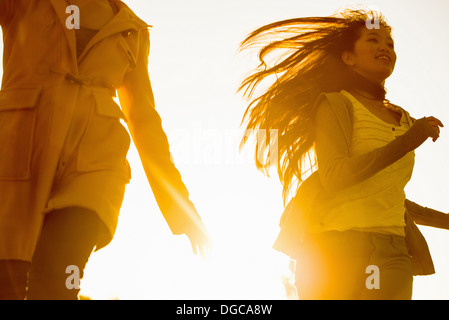 Due giovani amici di sesso femminile in esecuzione in posizione di parcheggio Foto Stock